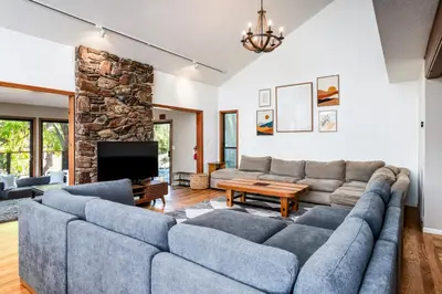 a living room with a large couch and a tv at Spacious Mountain View Oasis - Pool, Spa & Game Rm in Oakhurst