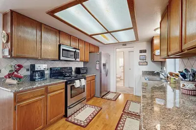 a kitchen with wooden cabinets and stainless steel appliances at Casa Cardoso in Groveland