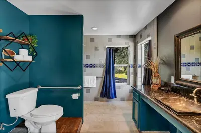 a blue bathroom with a toilet and a sink at Yosemite & Bass Lake 3 Acres, Pool, Game Room, Stunning Views in Coarsegold