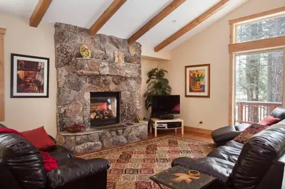 a living room with a stone fireplace and leather furniture at Luxury Home Near Lake, Heavenly, Casinos in South Lake Tahoe
