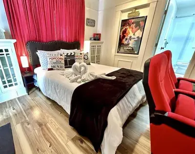 a bedroom with a bed and a red chair at Reno MidTown Movie House in Reno