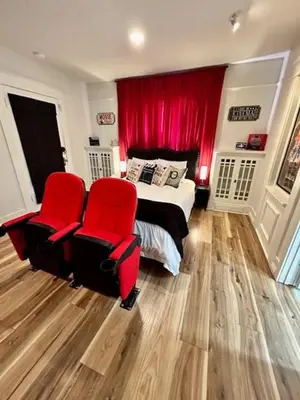 a bedroom with a bed and two red chairs at Reno MidTown Movie House in Reno