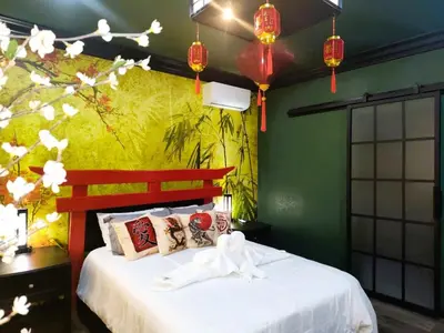 a bedroom with a bed with white sheets and a green wall at Asian Zen Den in Sparks