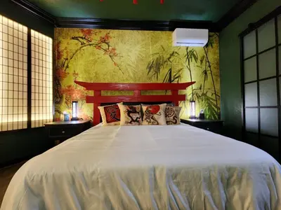 a bedroom with a large bed and a painting on the wall at Asian Zen Den in Sparks