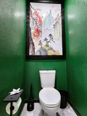 a green bathroom with a toilet and a painting at Asian Zen Den in Sparks