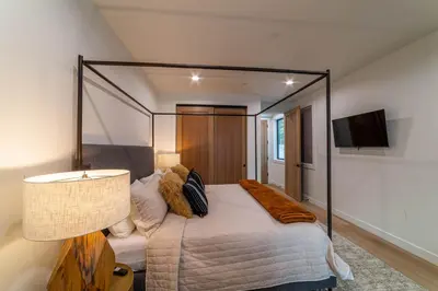 a bedroom with a canopy bed and a lamp at Spectacular New 4BR Townhome: Garage, Jacuzzi, BBQ in Mammoth Lakes