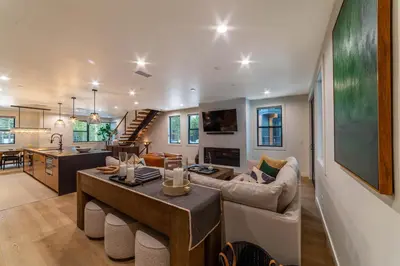 a living room and kitchen with a couch and a table at Spectacular New 4BR Townhome: Garage, Jacuzzi, BBQ in Mammoth Lakes