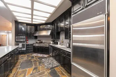 a kitchen with stainless steel appliances and a skylight at Yosemite Gateway Sleeps 18 - Coarsegold Villa near Bass Lake in Coarsegold