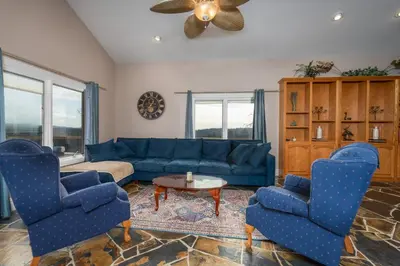 a living room with a blue couch and two chairs at Yosemite Gateway Sleeps 18 - Coarsegold Villa near Bass Lake in Coarsegold