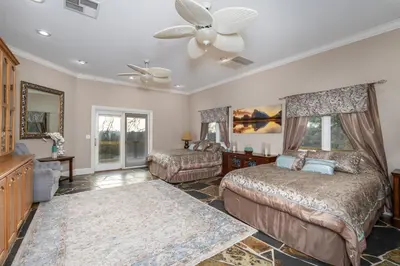 a bedroom with two beds and a ceiling fan at Yosemite Gateway Sleeps 18 - Coarsegold Villa near Bass Lake in Coarsegold