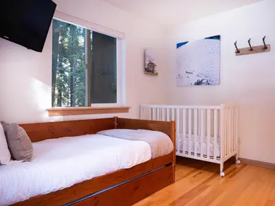 a bedroom with a crib and a window at Mountain Retreat near Skiing, HotTub, PetFriendly in Tahoe City