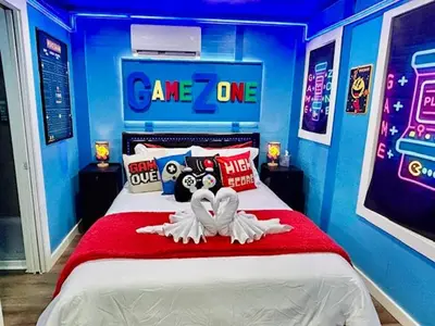 a blue room with a bed with a game zone sign at GameZone in Sparks