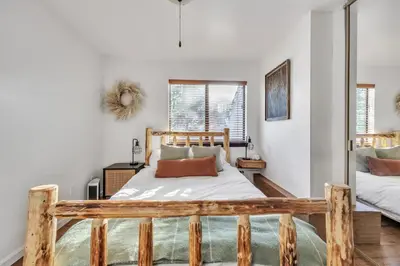 a bedroom with a wooden bed and two windows at Alpine Retreat in the Heart of Incline Village condo in Incline Village