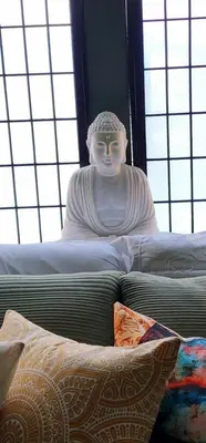 a statue of a man sitting on top of a bed at MidTown Zen Den in Reno
