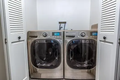 two washing machines in a laundry room with white cabinets at Luxurious Yosemite Pines Lodge, Pool, Spa, Ponies, Views in Mariposa