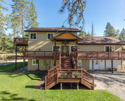 a large house with a large deck and a porch at Luxurious Yosemite Pines Lodge, Pool, Spa, Ponies, Views in Mariposa
