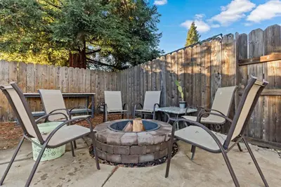 a patio with chairs and a fire pit in front of a fence at Huge House-Yard-Pool Hot Tub in Citrus Heights