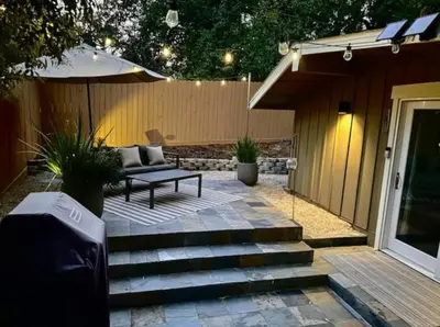 a patio with a bench and an umbrella at King Bed-Peaceful Modern Cottage-Garden Setting in Carmichael