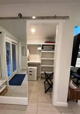 a room with a closet with a desk and a mirror at King Bed-Peaceful Modern Cottage-Garden Setting in Carmichael
