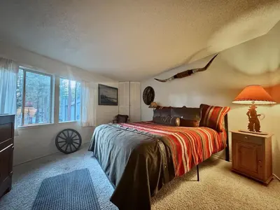 a bedroom with a bed and a lamp and a window at One The First Fairway - Walk to the Lake in Incline Village