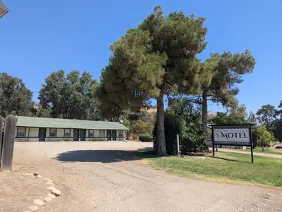 a motel sign and a tree in front of a building at Squaw Valley Motel Room 6 in Squaw Valley