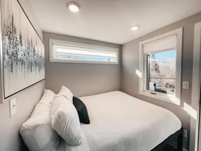 a small bedroom with a bed and a window at Beautiful and Elegant River Front Cottage in Reno