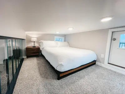a white bedroom with a large bed and a window at Beautiful and Elegant River Front Cottage in Reno