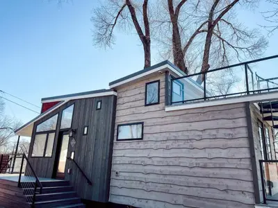 a wooden house with a glass roof and stairs at Beautiful and Elegant River Front Cottage in Reno