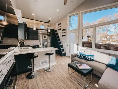 a small kitchen and living room with a couch and a sink at Beautiful and Elegant River Front Cottage in Reno