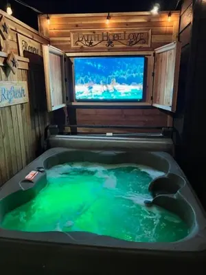 a bathroom with a green tub with a tv in it at Romantic Couples Retreat - Tahoe Room in Reno