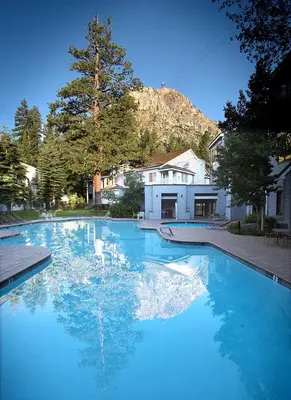 a large pool of blue water in front of a house at Palisades Tahoe Lodge Rentals Premium Fireplace One Bedroom #807 in Olympic Valley