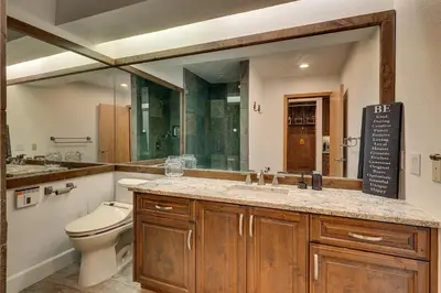 a bathroom with a toilet and a sink and a mirror at Palisades Tahoe Lodge Rentals Premium Studio Loft #358 in Olympic Valley