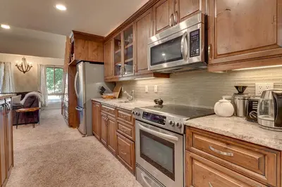 a kitchen with wooden cabinets and stainless steel appliances at Palisades Tahoe Lodge Rentals Premium Studio Loft #358 in Olympic Valley