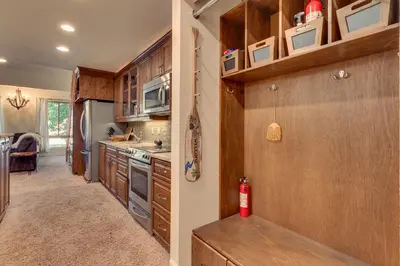 a kitchen with wooden cabinets and a fire extinguisher at Palisades Tahoe Lodge Rentals Premium Studio Loft #358 in Olympic Valley