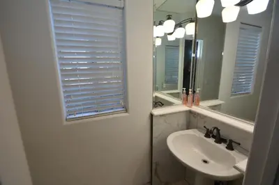 a white bathroom with a sink and a mirror at Bearadise At North Shore Winter Special in Bass Lake