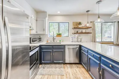 a kitchen with blue cabinets and stainless steel appliances at Blue Basecamp - Adventure Starts HERE! in Shaver Lake