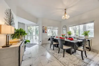 a dining room with a table and chairs on a rug at Rudraksha-Luxurious 5 BR House, Prime Location, Shopping, Dining, Medical, Education, Tourist Attractions in Fresno