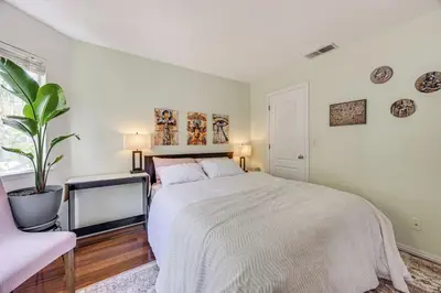 a white bedroom with a bed and a potted plant at Rudraksha-Luxurious 5 BR House, Prime Location, Shopping, Dining, Medical, Education, Tourist Attractions in Fresno