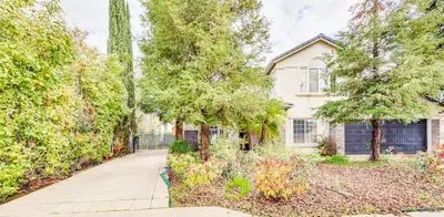 a white house with trees and a driveway at Rudraksha-Luxurious 5 BR House, Prime Location, Shopping, Dining, Medical, Education, Tourist Attractions in Fresno