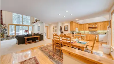a kitchen and dining room with a table and chairs at Pinewood Lodge by AvantStay Cozy Cabin Near Ski Resorts Hiking in Truckee