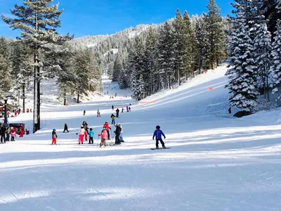 a group of people skiing down a snow covered slope at 3BR Condo Near Lake & Skiing in Incline Village