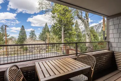 a wooden bench on a balcony with a view at Cedar and Snow in Mammoth Lakes