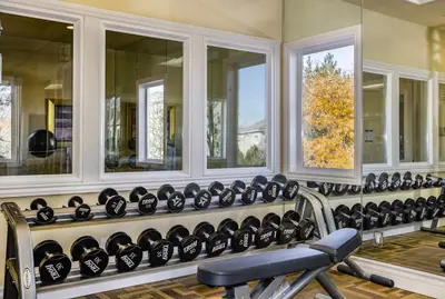 a gym with a row of mirrors and a bench at New Stylish 1BR Apt with Heated Pool Gym & Yoga Studio in Reno