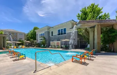 a swimming pool with chairs and a water fountain at New Stylish 1BR Apt with Heated Pool Gym & Yoga Studio in Reno