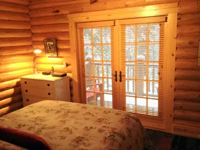 a bedroom with a bed and a window in a log cabin at Family-Friendly Log Cabin Rental in California's Gold Country near Sacramento in Volcano