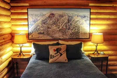 a bedroom with a bed with two lamps and a map at Family-Friendly Log Cabin Rental in California's Gold Country near Sacramento in Volcano