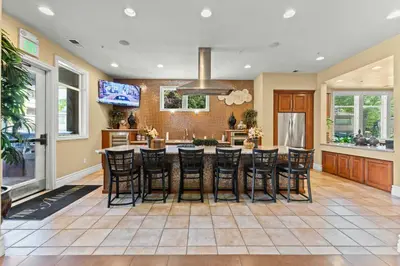 a kitchen with a large island with bar stools at New Cozy 1BR Apt with Gym Sauna & Heated Pool Access in Reno