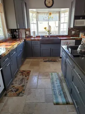 a kitchen with blue cabinets and a tile floor at Newly remodeled mountain home! in Floriston