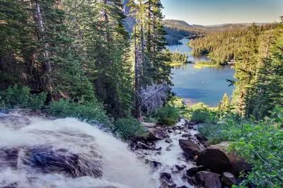 a river flowing through a forest next to a lake at Summit 295 in Mammoth Lakes