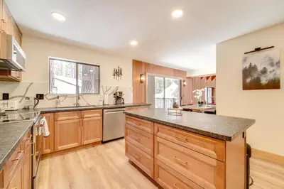 a kitchen with wooden cabinets and a large counter top at Ski, Hike and Fish Cabin with Deck in Soda Springs! in Soda Springs